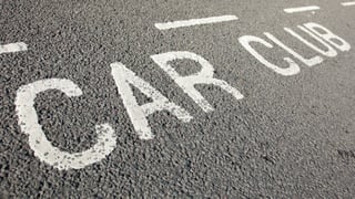 The words "Car club" painted on the tarmac of the edge of a parking bay