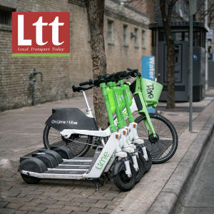 Local Transport Today logo alongside e-scooters and an e-bike parked on the carriageway