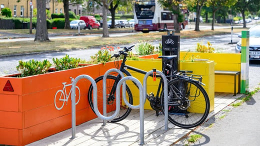 Pop-up mobility hub with locked bike, planters, seated area and bike maintenance stand