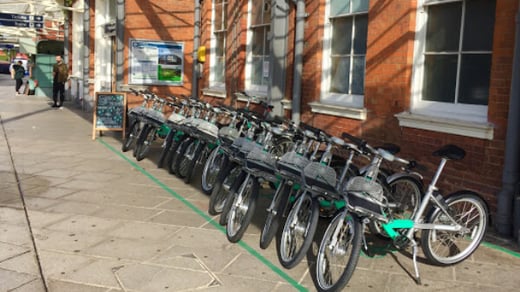 Beryl shared bikes parked in a designated bay outside a railway station